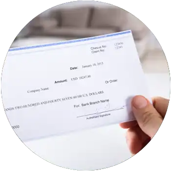 A light-skinned hand holds a signed blue and white check for $10,247.40.