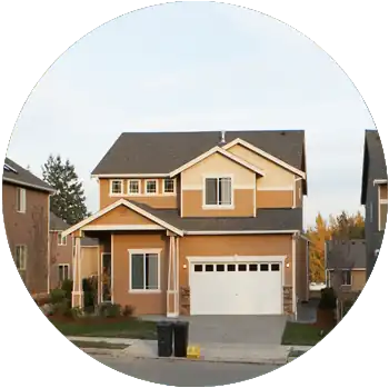 A row of houses are on a suburban street with a clear sky in the background.