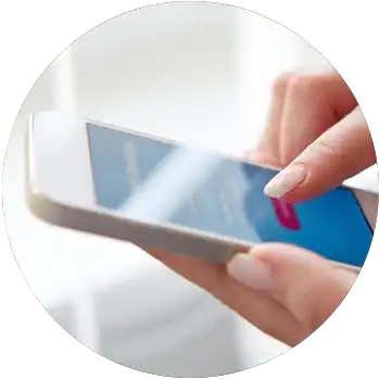 A light skinned hand with long, manicured nails taps a button on a white iPhone.